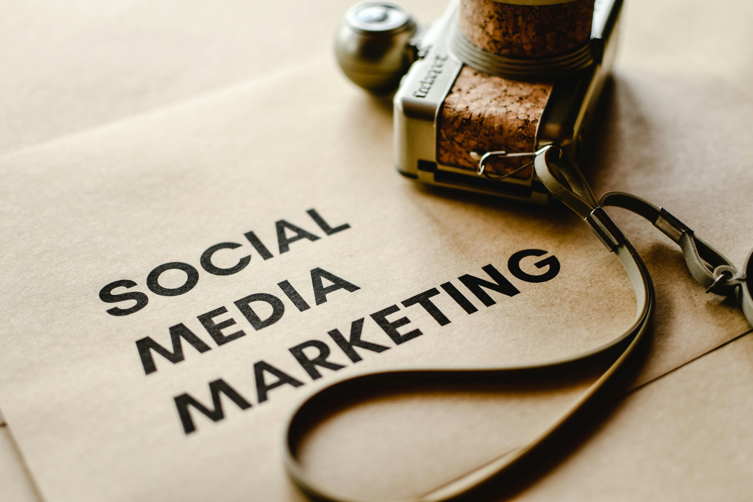 Home Close-up of a camera placed on brown paper with 'Social Media Marketing' text, emphasizing digital marketing themes.